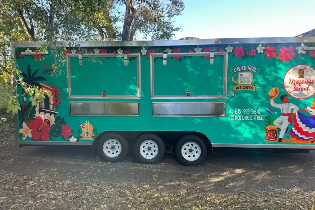 Side view of the Mofongo Street food truck with its order windows and phone number